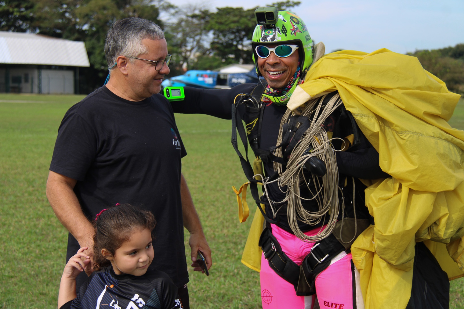 Paraquedista Elite Suits com bermuda rosa cumprimentando família