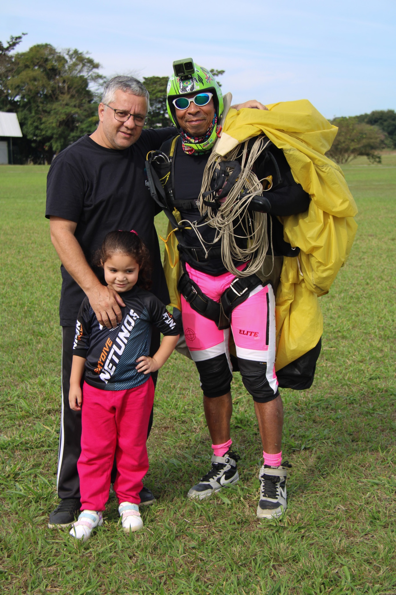 Paraquedista Elite Suits com bermuda rosa posando com família