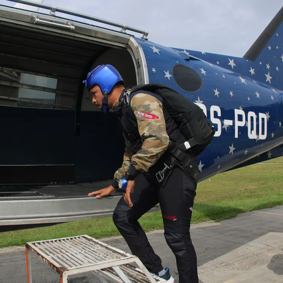 Paraquedista embarcando no avião com macacão Elite Suits camuflado