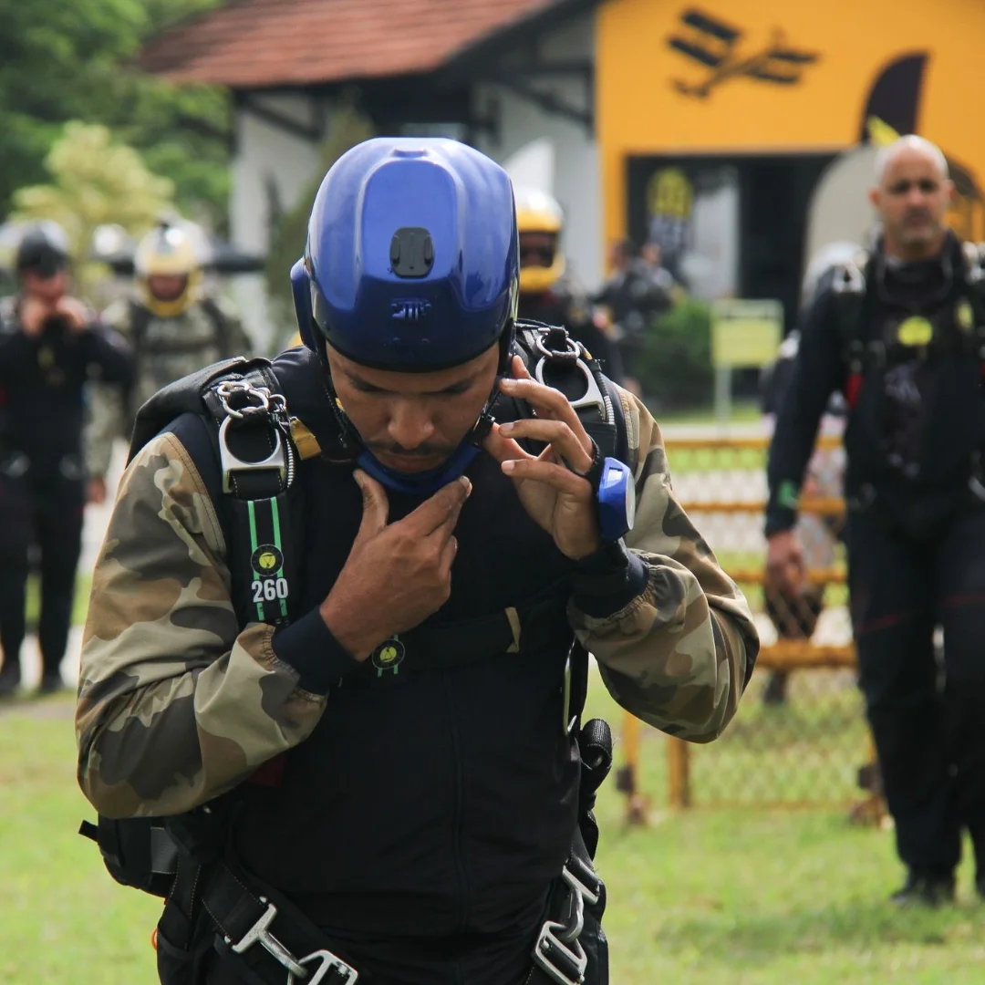Paraquedista ajustando equipamento com vestimenta Elite Suits camuflada